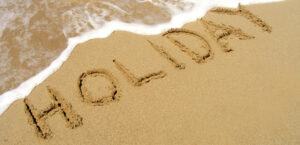 beach with holiday written in the sand