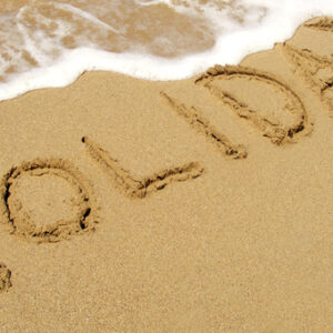 beach with holiday written in the sand