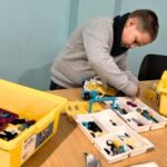 boy building with LEGO Spike pieces